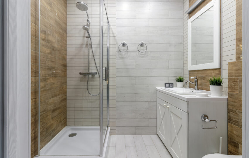 3 Reasons Why Now Is the Time To Remodel Your Home A clean and functional bathroom design featuring modern fixtures, wooden accents, and a glass-enclosed shower creating a warm and inviting atmosphere