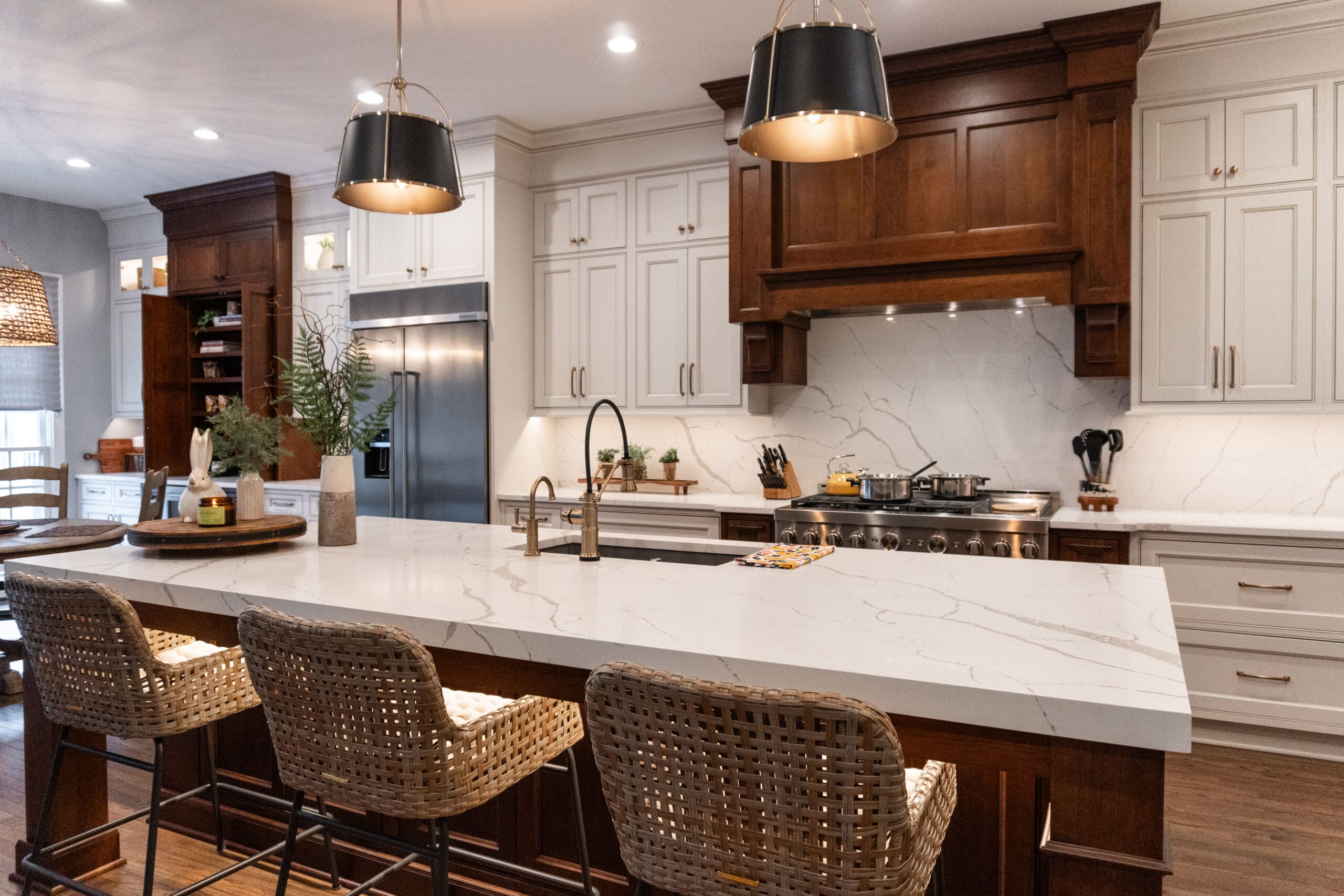 transformed kitchen in Fair Oaks VA - mixed antique white and walnut cabinets and marble slab backsplash
